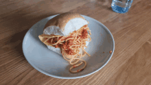 a white plate topped with a spaghetti sandwich