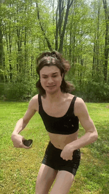 a man in a bikini top and shorts is standing in a grassy field