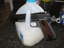 a gun is resting on a gallon of milk