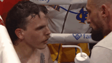 a man in a boxing ring with a far logo on the side of his shirt