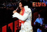 a man singing into a microphone with the word elvis in red