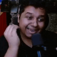 a man is talking into a microphone while smiling .