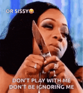 a woman is holding a knife to her face and saying `` do n't play with me don 't be ignoring me ''