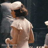 a woman is wearing a hat and gloves and the hashtag #sinnersmovie is on the bottom of the image