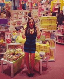 a woman in a blue and black striped dress stands in a store