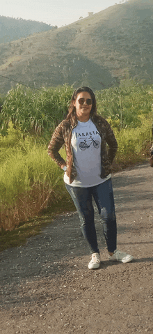 a woman wearing a t-shirt that says jakarta is standing on a road