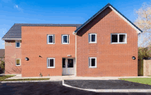 a large red brick building with a black roof