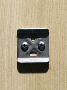 a metal piece with two screws on it looks like a smiley face