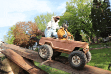 a toy jeep is going down a wooden slope