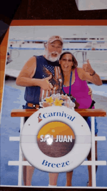 a man and woman are posing for a picture in front of a sign that says carnival breeze