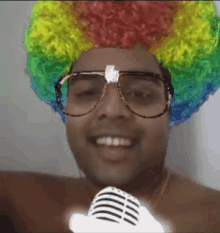 a man wearing a clown wig and glasses is smiling and holding a microphone