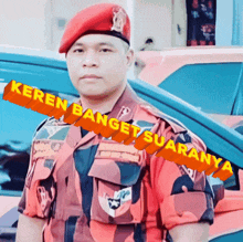 a man wearing a red beret stands in front of a car with the words keren banget suaranya written on the bottom