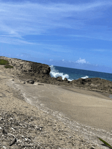 waves crashing against a rocky shoreline on a sunny day