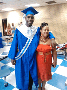 a man in a graduation cap and gown poses with a woman