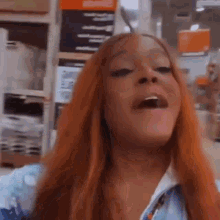 a woman with red hair is making a face in a store .