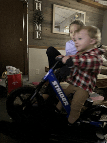 a toddler riding a strider bike next to a girl