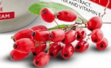 a bunch of red berries are sitting on a table next to a bottle of vitamin e .