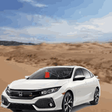 a white honda car is parked in the desert