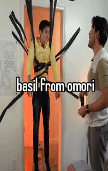 a man in a yellow hoodie is tied up with black tape and says basil from omori on the bottom