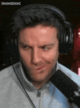 a man wearing headphones is making a face in front of a microphone with jawshiedomi written on the bottom right