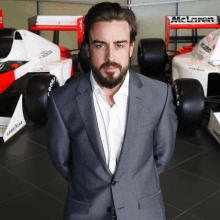 a man stands in front of a mclaren race car