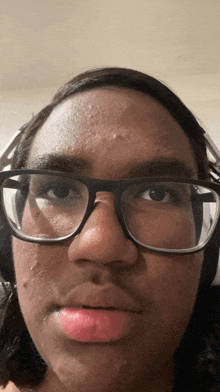 a close up of a person 's face with glasses on