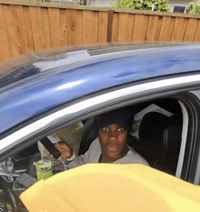 a woman is sitting in a car with a yellow blanket on the dashboard