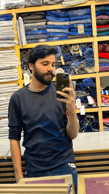 a man with a beard is taking a picture of himself in a mirror