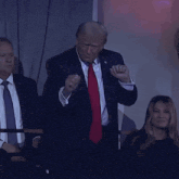 a man in a suit and tie is dancing in front of a group of people
