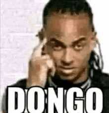 a man with dreadlocks is talking on a cell phone and has the word dongo written on his face .