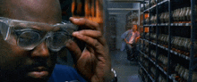 a man wearing safety goggles looks at something in a warehouse