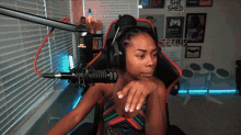 a woman wearing headphones sits in front of a microphone in a room that has a sign that says she shed