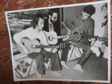 a black and white photo of three men playing guitars with the website www.todocoleccion.net at the bottom