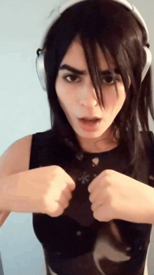a woman wearing headphones and a black tank top