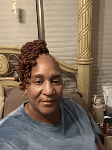 a woman with dreadlocks and a nose ring sits on a bed