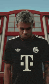 a man wearing a black shirt with the letter t on the front