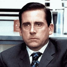 a man in a suit and tie is making a face