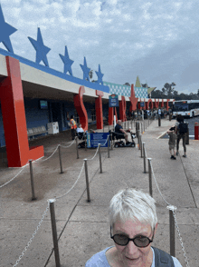 a woman wearing sunglasses stands in front of a building that says ' texas ' on it