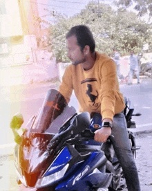 a man in a yellow sweatshirt is sitting on a motorcycle .