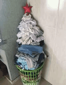 a christmas tree made out of clothes in a laundry basket with a star on top .