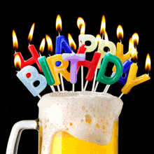 a beer mug with a bunch of birthday candles on top of it