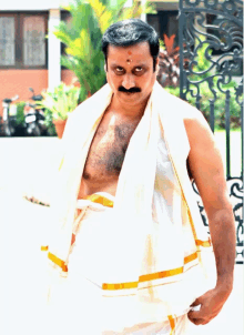 a man with a mustache is wearing a white towel around his waist