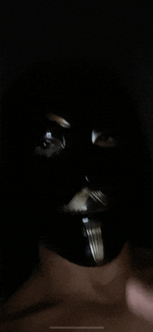 a close up of a person wearing a black mask with a fork in it .