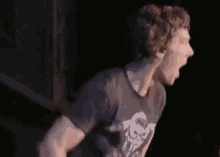 a man in a black shirt is holding his hand to his mouth and says `` omg '' .