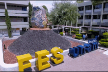 a large sculpture of a globe sits on top of a pile of rocks with the letters fes on the ground