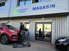 a man is riding a scooter in front of the magasin