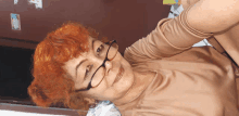 a woman with red hair and glasses is laying down