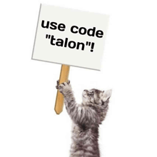 a kitten is holding up a sign that says use code talon .