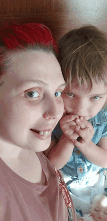 a woman with red hair is holding a little boy