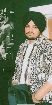 a man wearing a turban and a leopard print shirt is standing with his hands in his pockets